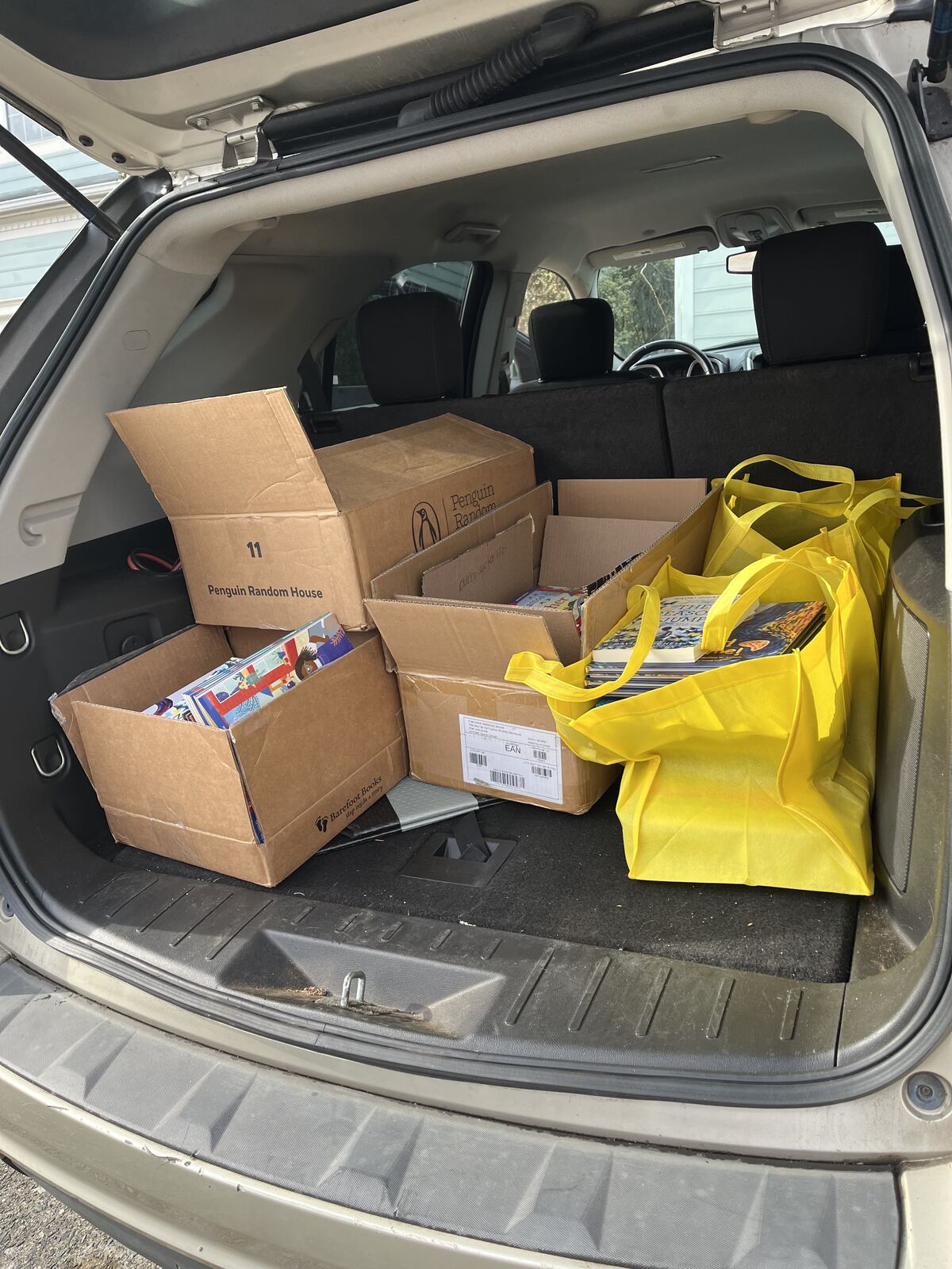 Car trunk filled with boxes of books for donation