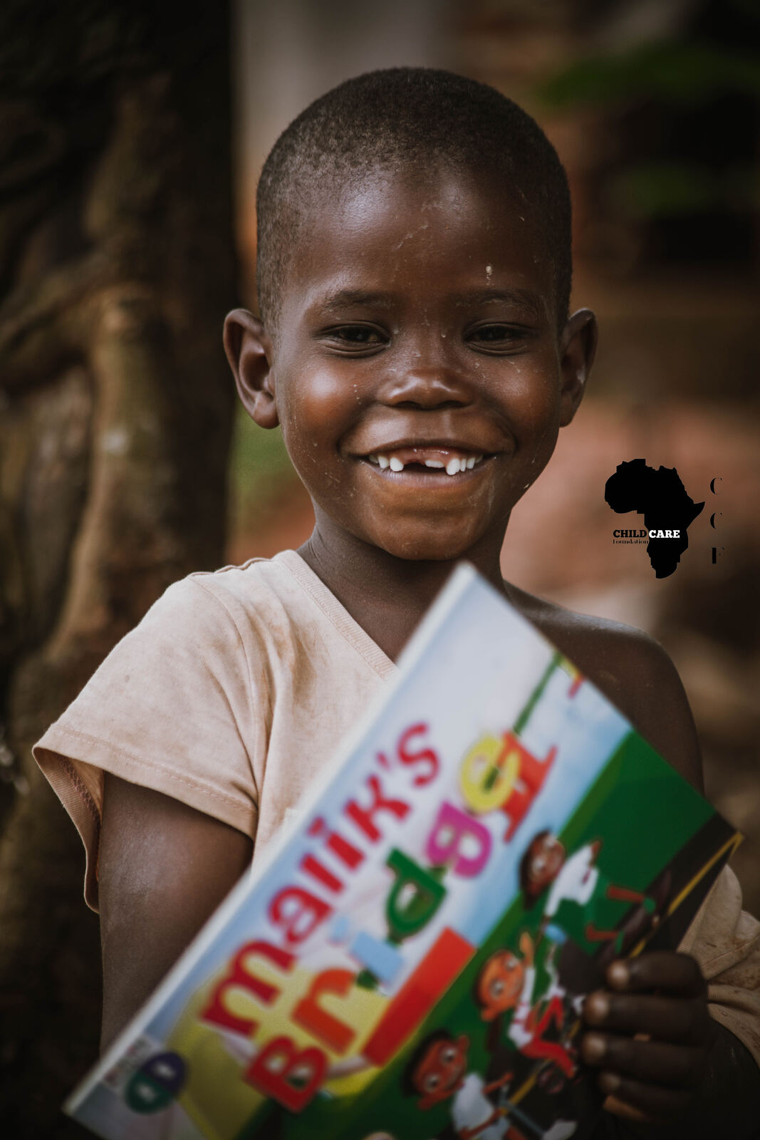 Smiling boy holding a donated picture book
