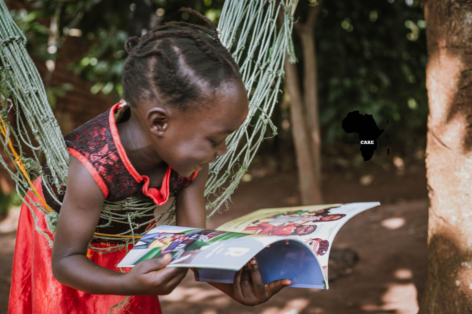 Young girl reading a donated book outdoors