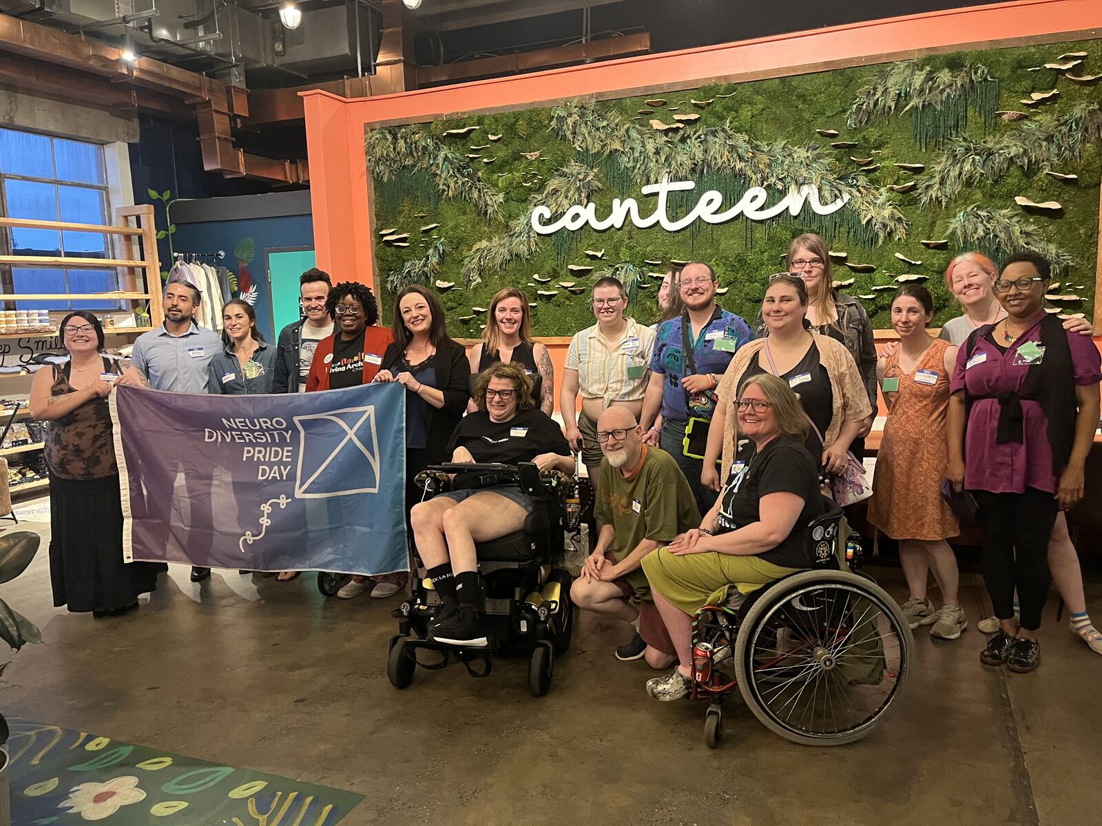 Community members gathered with a Neurodiversity Pride Day banner
